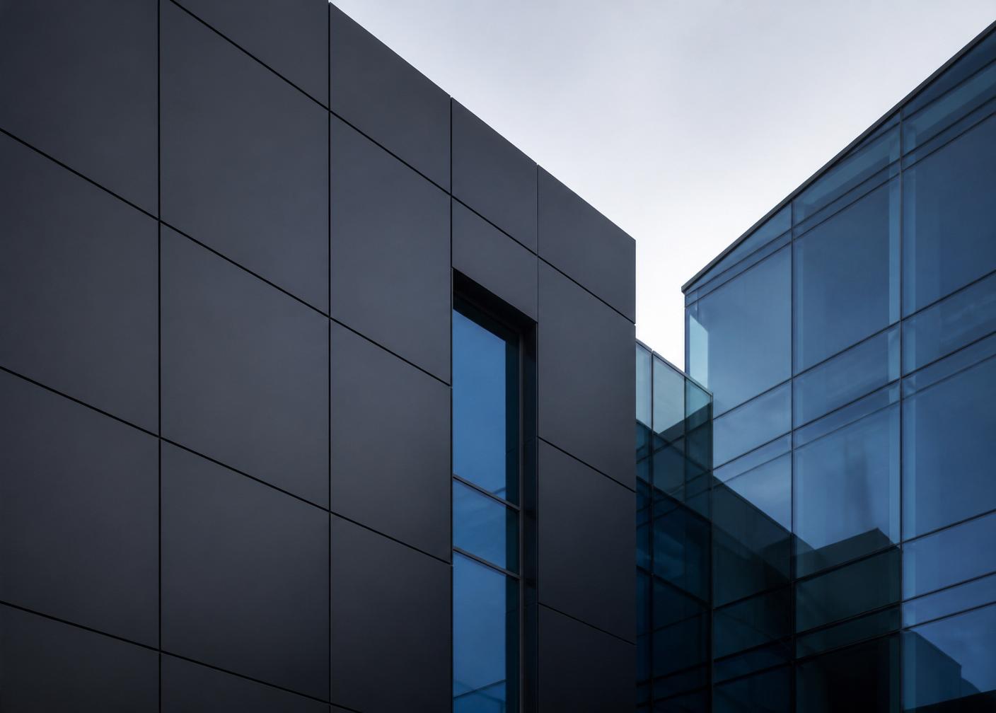 Minimalistische Kanzlei- und Praxisfassade aus dunklem Metall und blau getöntem Glas – steht für Diskretion, Substanz und einen festen Standort in Deutschland